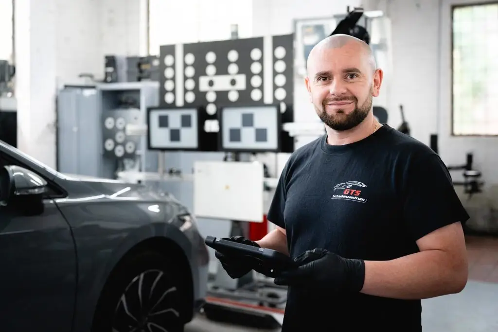 GTS Schadenzentrum Berlin Kfz Werkstatt Automechaniker in der Werkstatt mit Tablet